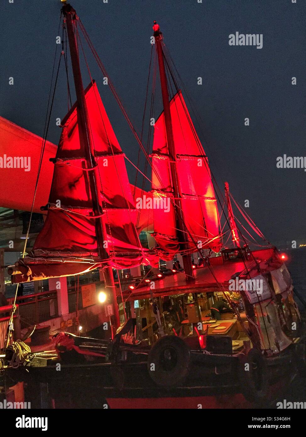 The 'Duk Ling', a restored 1950s Chinese fishing junk, picks up passengers for a sightseeing tour of Victoria Harbour, Hong Kong - Smartphone Captured Stock Image