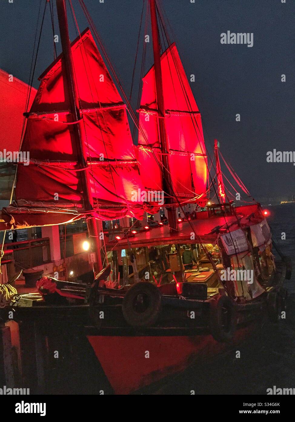 The 'Duk Ling', a restored 1950s Chinese fishing junk, picks up passengers for a sightseeing tour of Victoria Harbour, Hong Kong - Smartphone Captured Stock Image