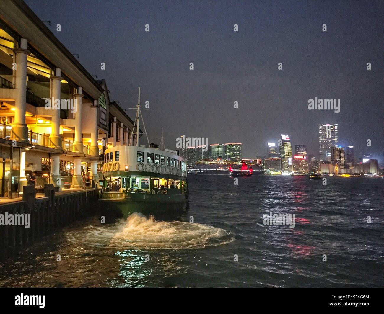 A Star Ferry leaves Hong Kong Island to take passengers across Victoria Harbour to Tsim Sha Tsui in Kowloon - Smartphone Captured Stock Image
