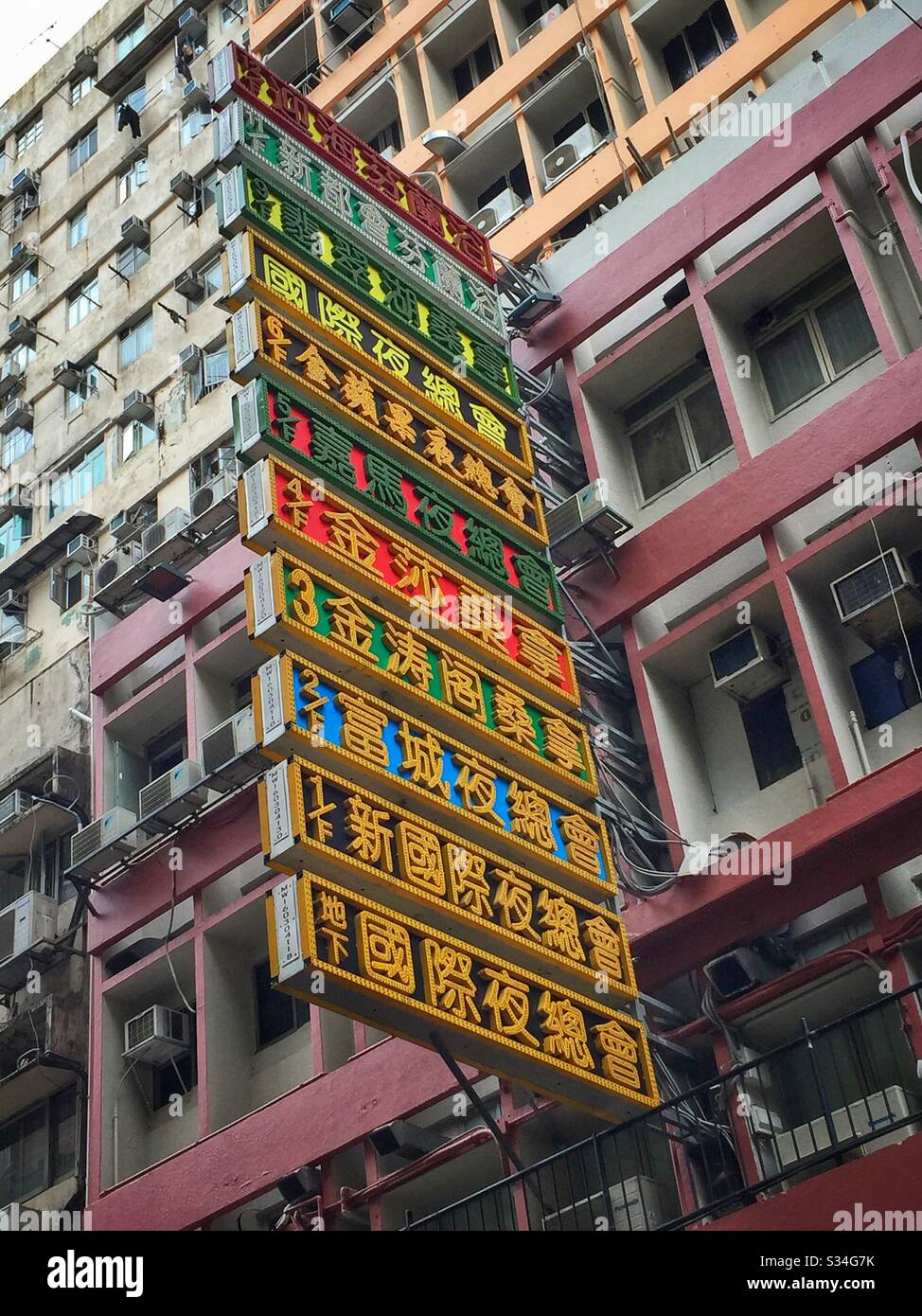 Huge neon sign acts as a floor directory to a building in Yau Ma Tei, Kowloon, Hong Kong - Smartphone Captured Stock Image