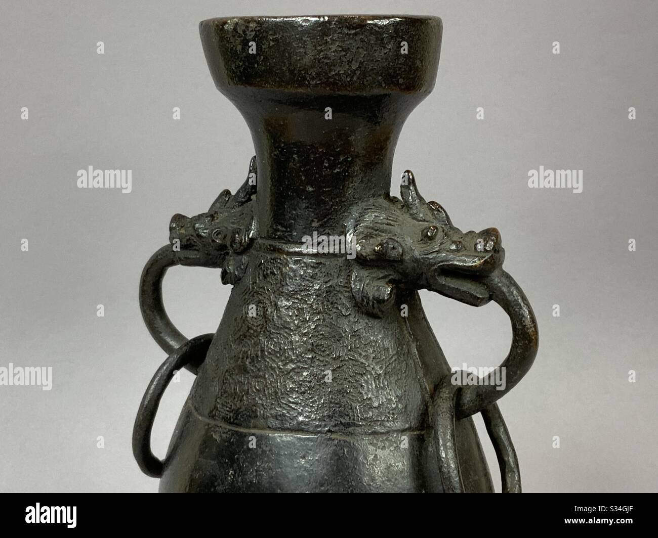 A Chinese Ming Dynasty 14th/15th century cast bronze vase with beast head handles & loops Stock Photo