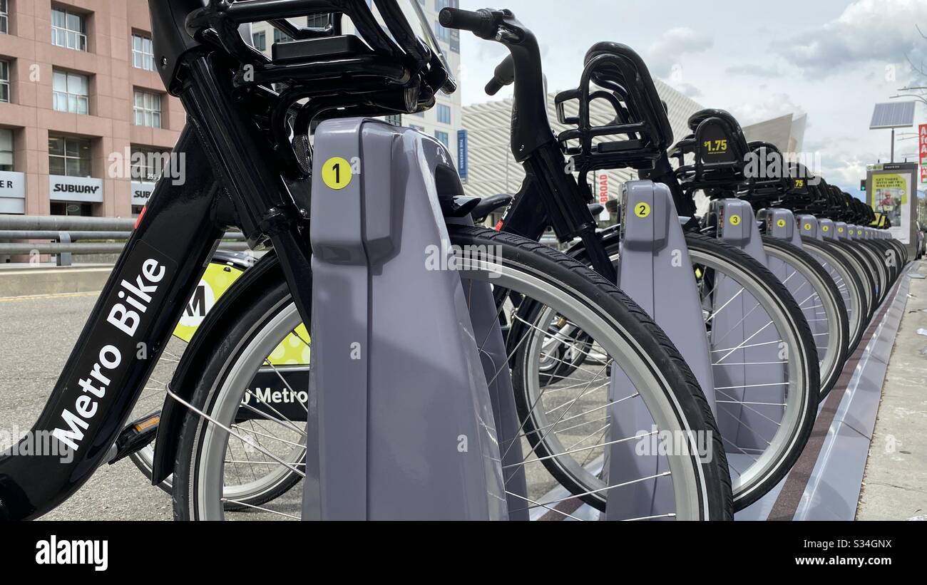 LOS ANGELES, CA, MAR 2020: low angle detail of black and green LA Metro Bike Share rental bicycles lined up in dock near museums in Downtown - Smartphone Captured Stock Image