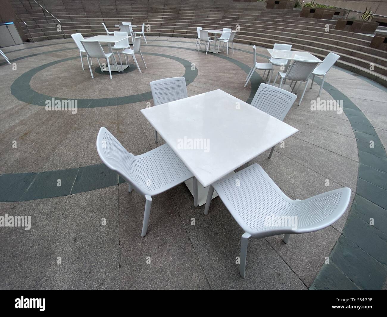 LOS ANGELES, CA, MAR 2020: wide angle view of empty white-coated steel chairs and tables in Downtown during coronavirus, Covid-19 'stay at home' order Stock Photo