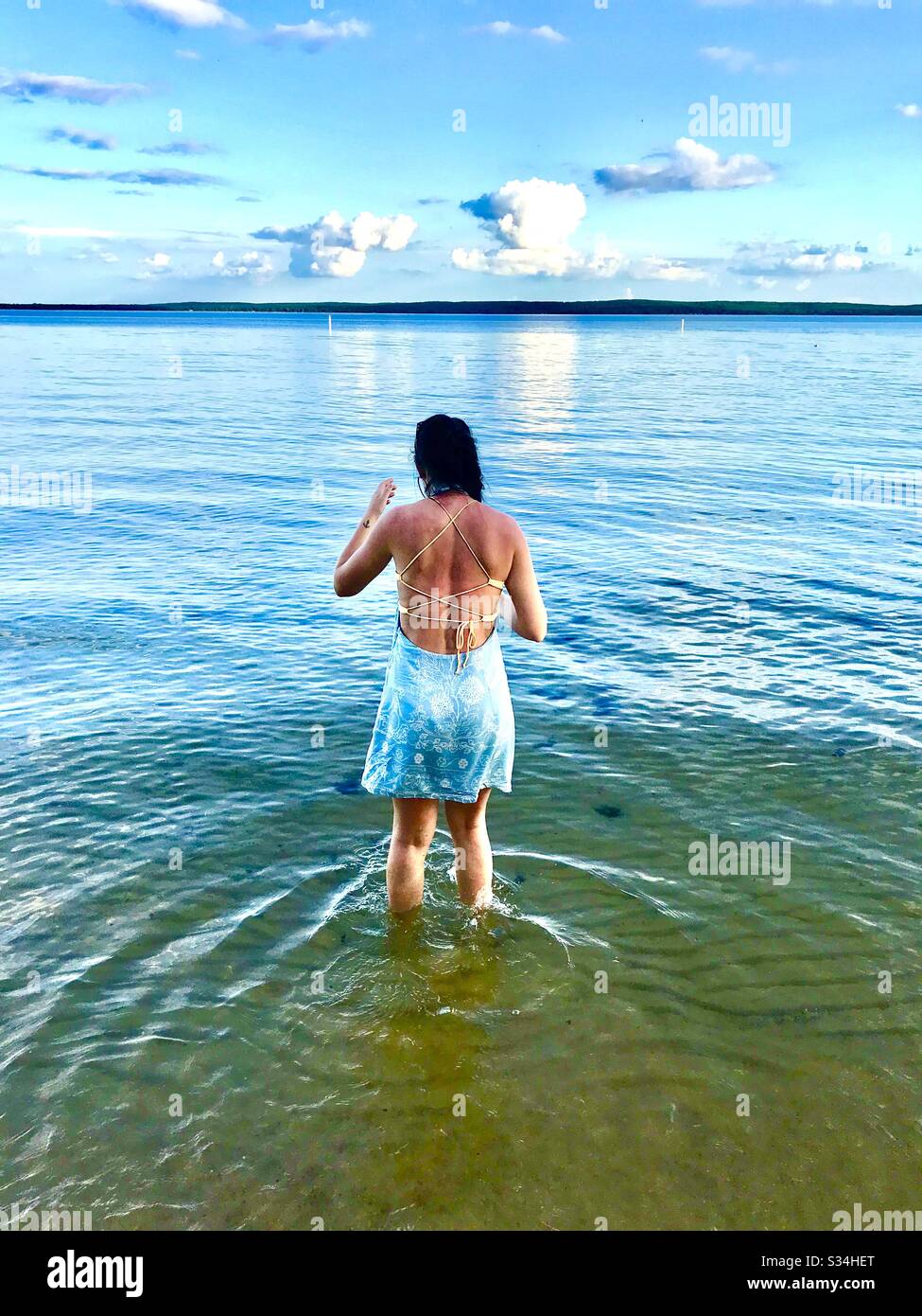 Woman wading in lake in evening - Smartphone Captured Stock Image