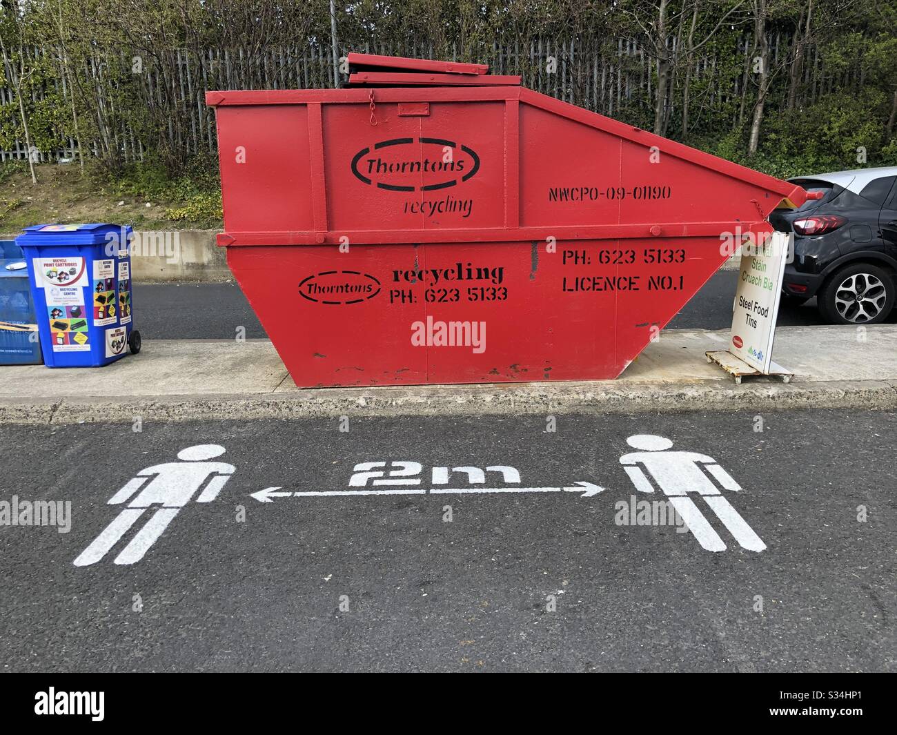 Social distancing notice, directing visitors to keep 2 meters apart, painted on to the road at a public recycling facility in Dublin Ireland amid the Coronavirus crisis. 28th March 2020. - Smartphone Captured Stock Image