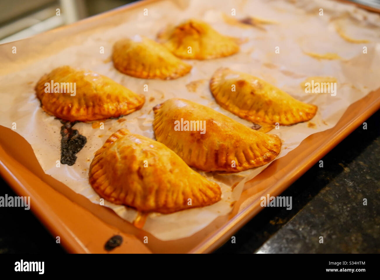 Home made empanadas on a baking tray just coming out of the oven Stock Photo