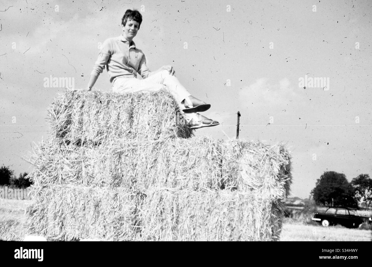 Beautiful woman sitting on top of Giant haystack - Smartphone Captured Stock Image