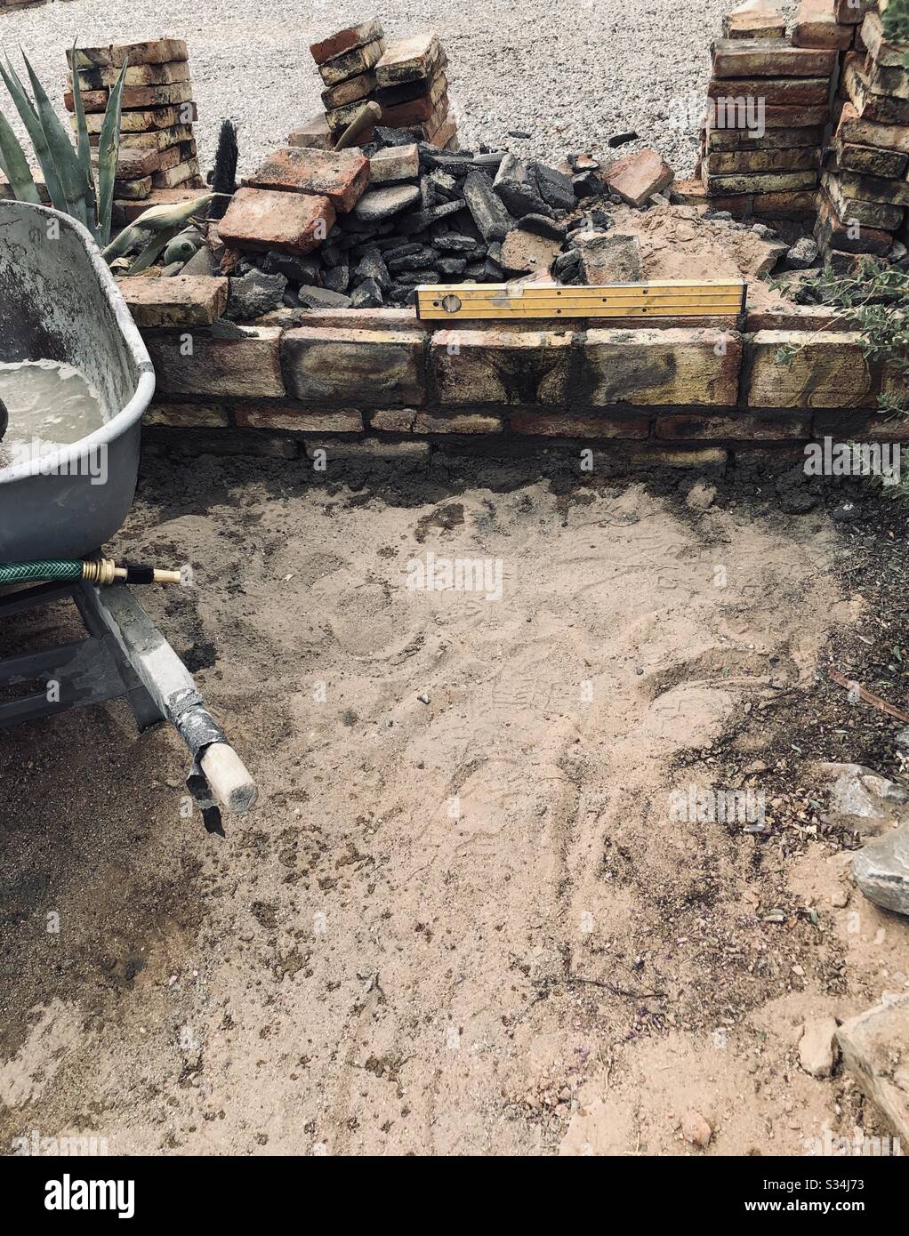 Textures, construction, brick wall, Mexican bricks, wheelbarrow, hose