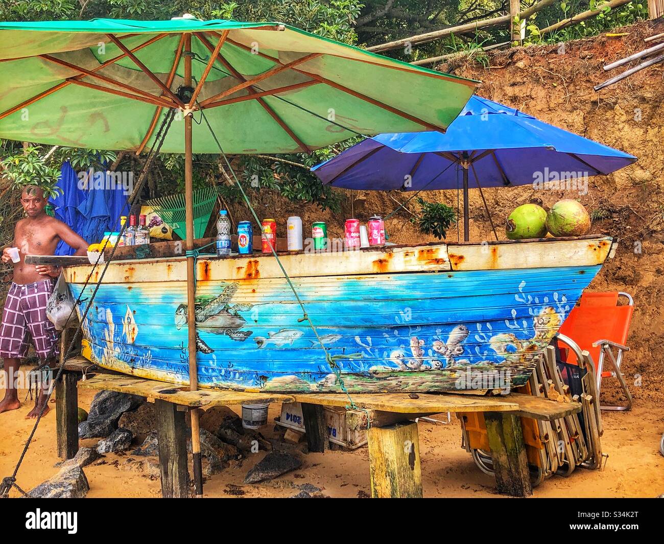 Rustic beach bar in in an old painted fishing boat. Stock Photo