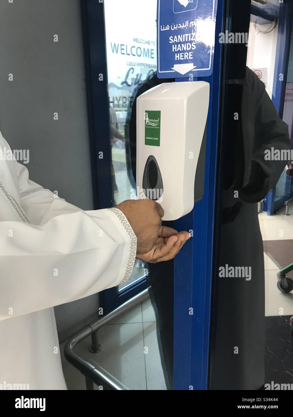 Public Hand sanitizer : a man uses a hand sanitizer at a local supermarket - Smartphone Captured Stock Image
