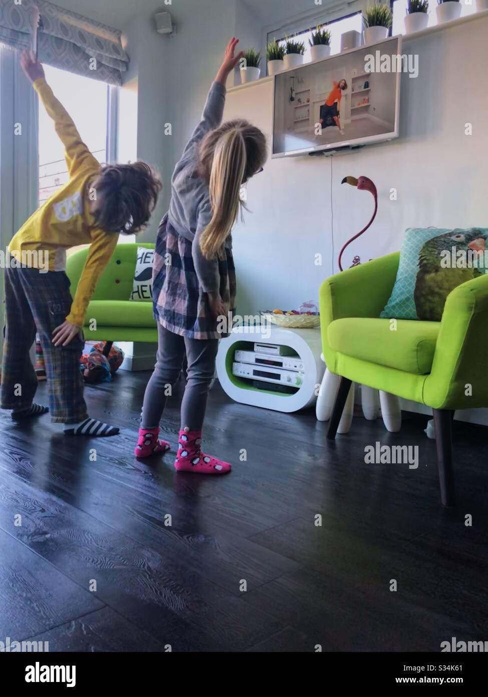 Two children doing Joe Wicks online PE lesson during UK Coronavirus lockdown. - Smartphone Captured Stock Image