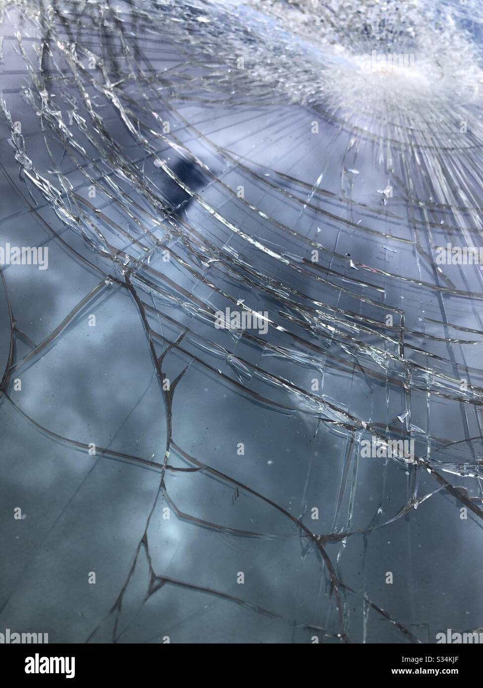 Close Up of a Smashed Windscreen with Reflection of Sky Stock Photo