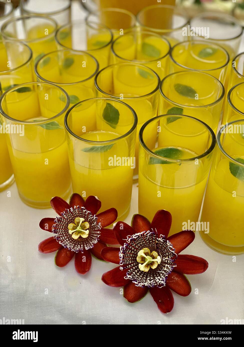 Refreshing passion fruit juice! Displayed are the enchanting Passion flowers. Squeezed from freshly-harvested passion fruit oozes a beautiful citrus flavor with a sweet note. Refreshed with mint. Stock Photo