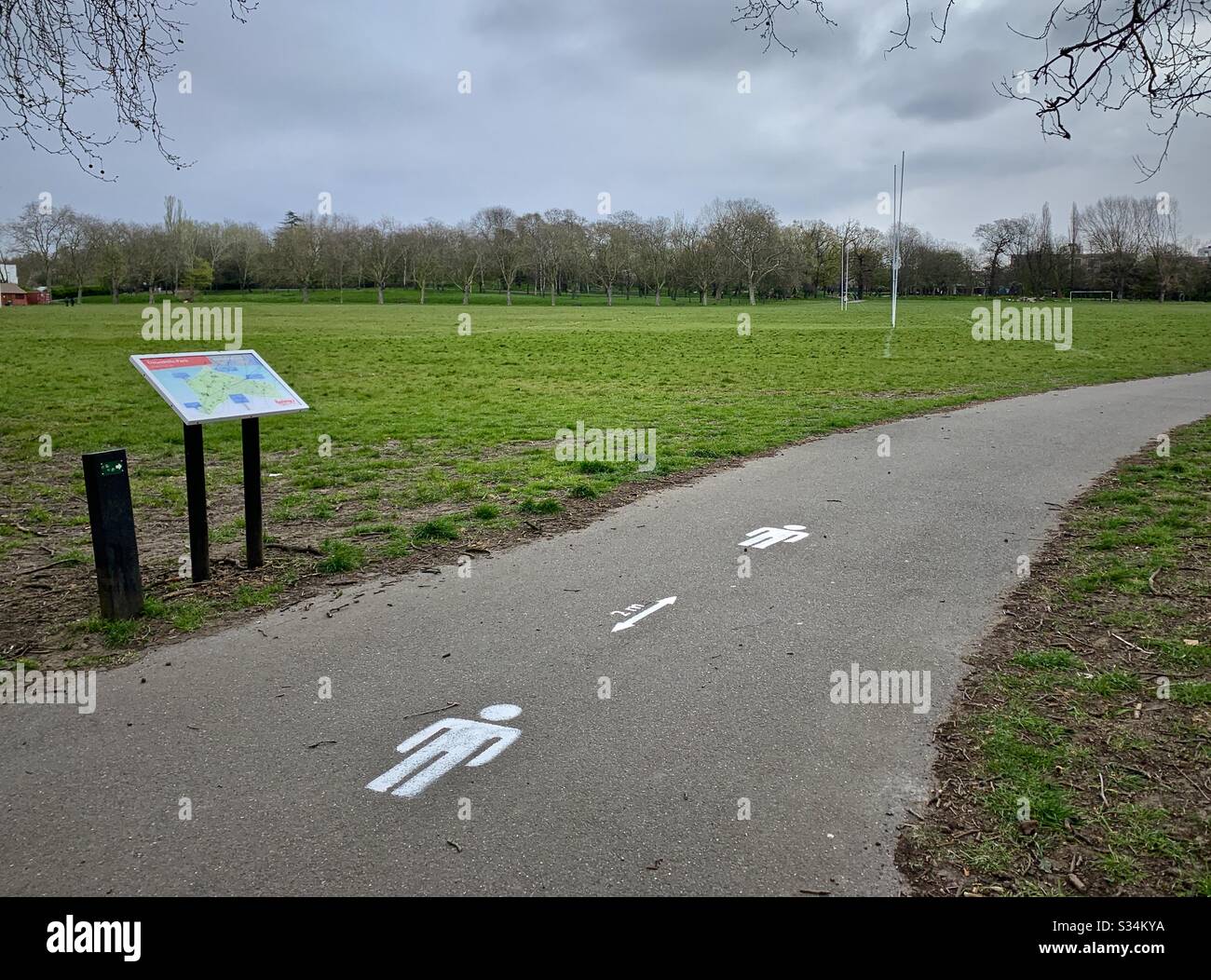 Social distancing stencils in a London Park Stock Photo