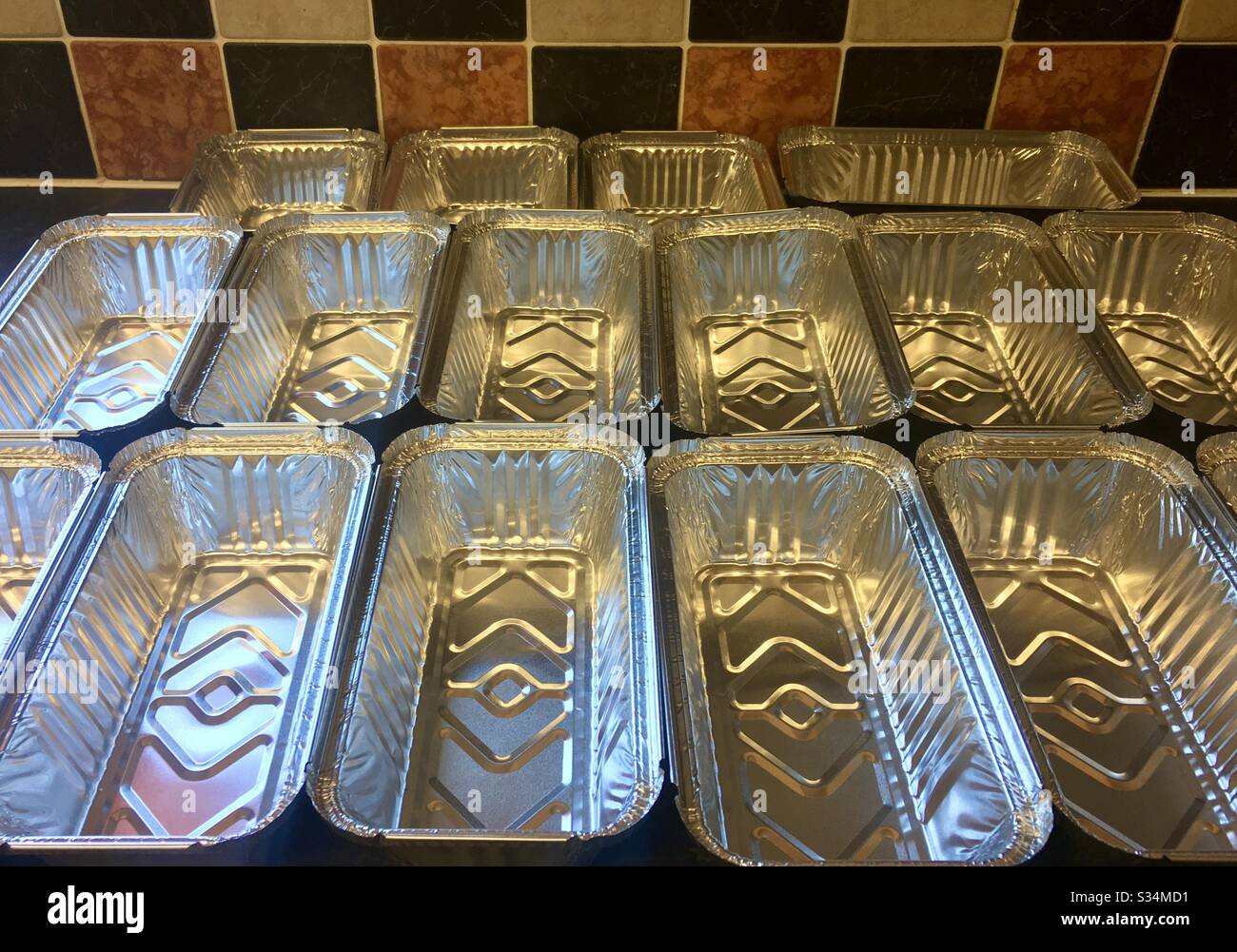 https://c8.alamy.com/comp/S34MD1/tin-foil-containers-ready-to-be-filled-in-a-prep-kitchen-S34MD1.jpg