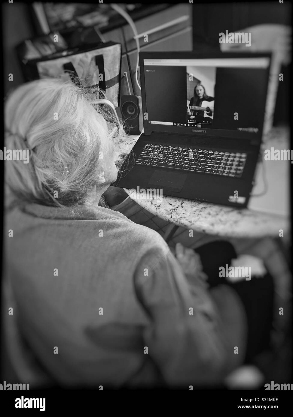 Grandmother watching video of grandson on Instagram while socially isolating during coronavirus quarantine. Stock Photo