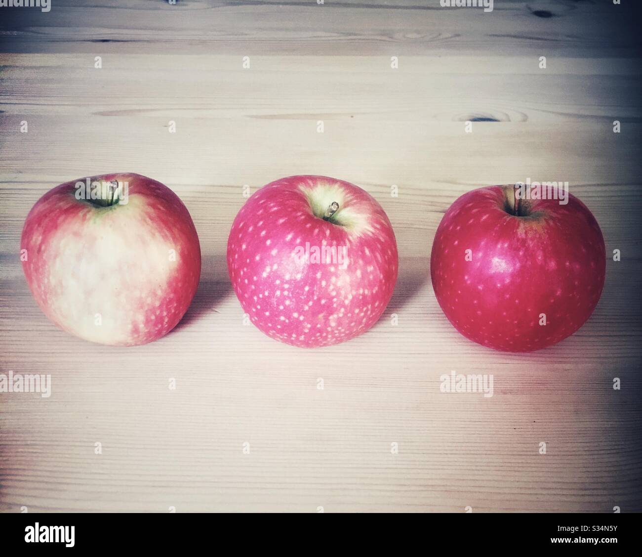 Three red apples in a line Stock Photo Alamy