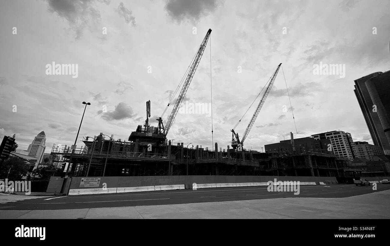 LOS ANGELES, CA, MAR 2020: silhouetted cranes working on construction of new Frank Gehry-designed building, opposite Walt Disney Concert Hall in Downtown. Black and white - Smartphone Captured Stock Image