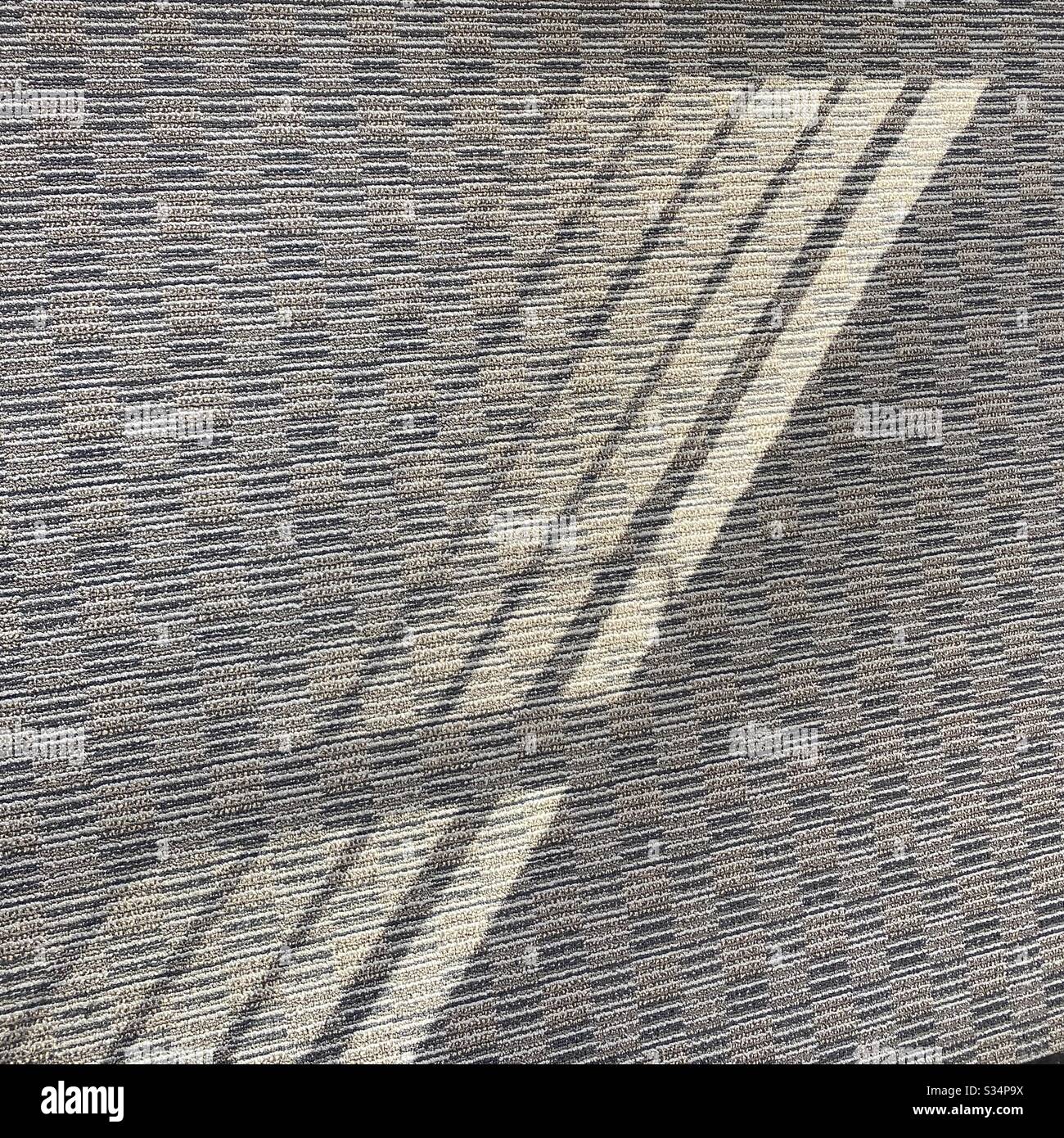 Abstract background created by sun shining through Venetian blinds, throwing shadows and light on to a patterned carpet - Smartphone Captured Stock Image Abstract background created by sun shining through Venetian blinds, throwing shadows and light on to a patterned carpet - Smartphone Captured Stock Image