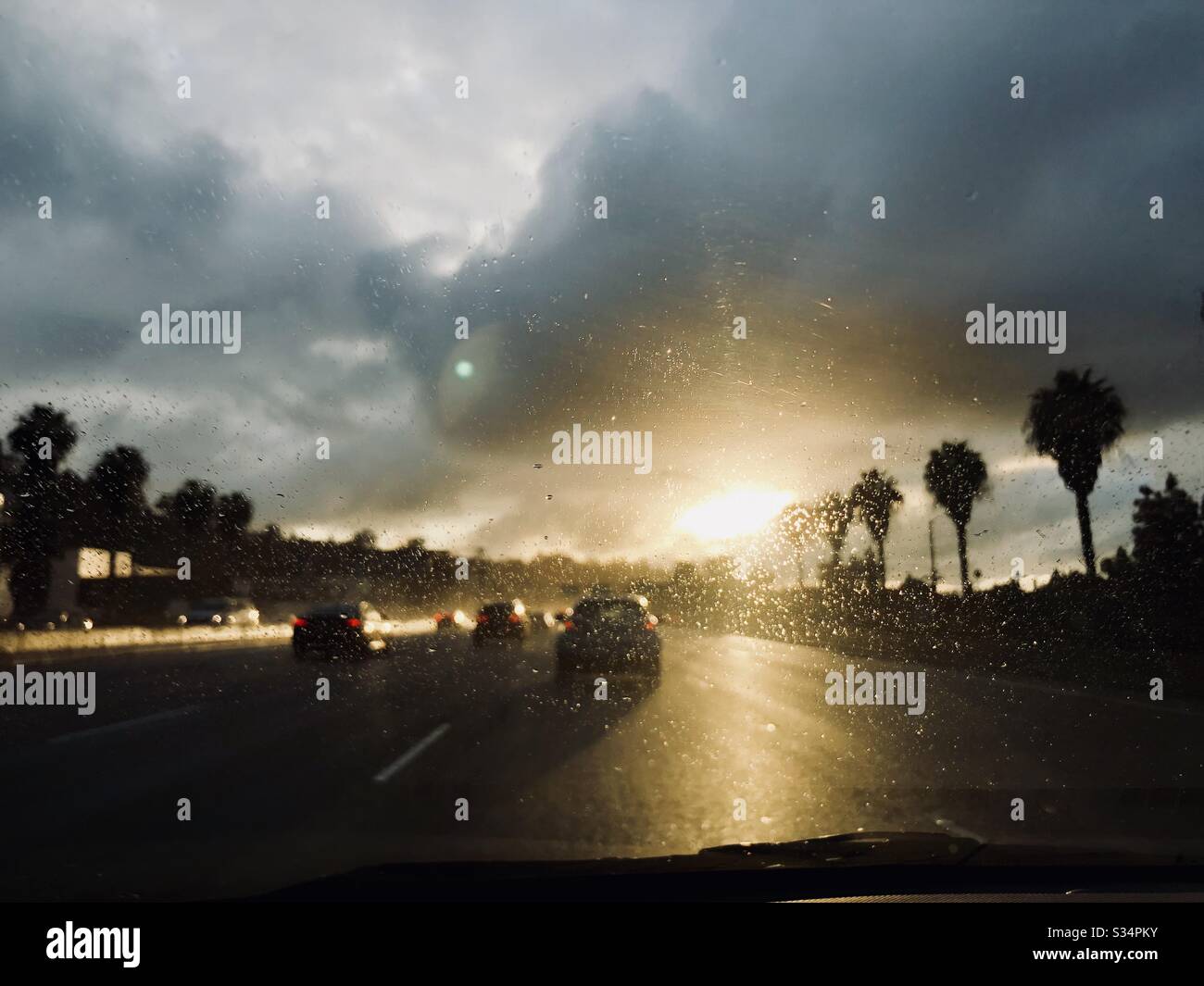 Looking down the highway at the sunset after rain. - Smartphone Captured Stock Image