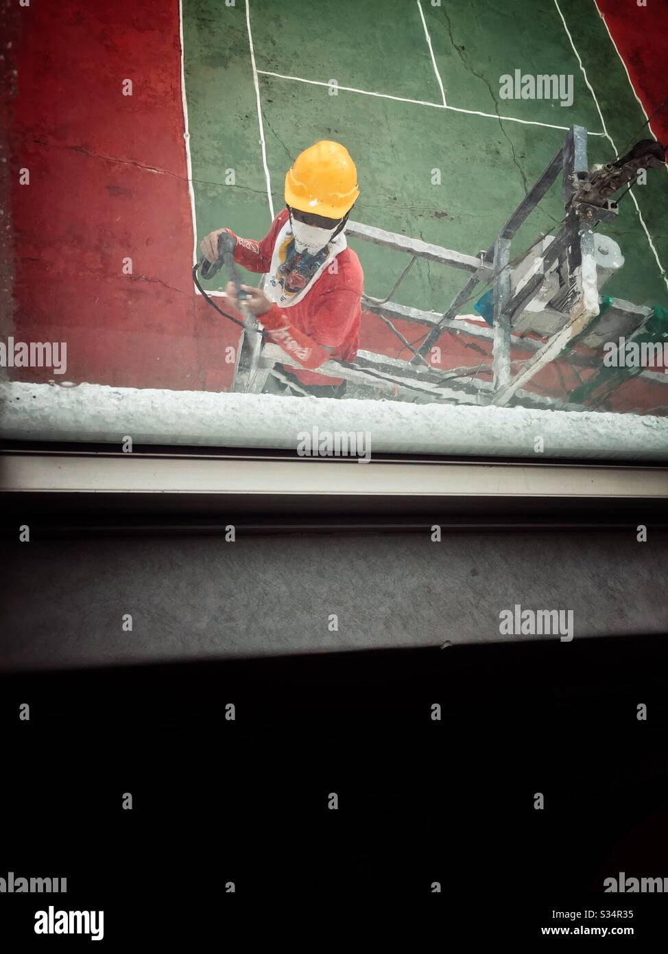 A worker cleaning the hotel window. - Smartphone Captured Stock Image