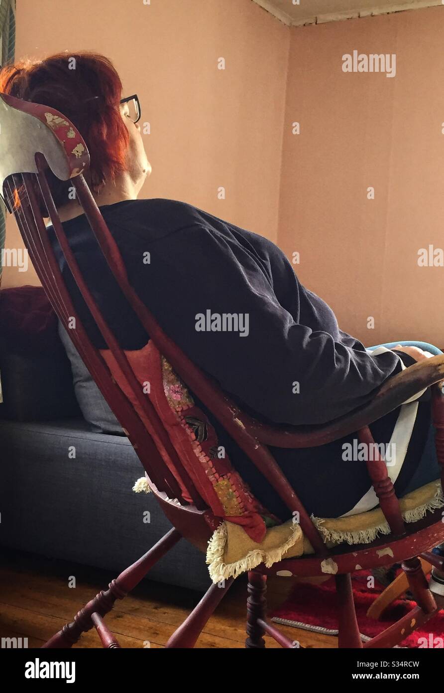 60-year-old woman in quarantine relaxes in a rocking chair. - Smartphone Captured Stock Image