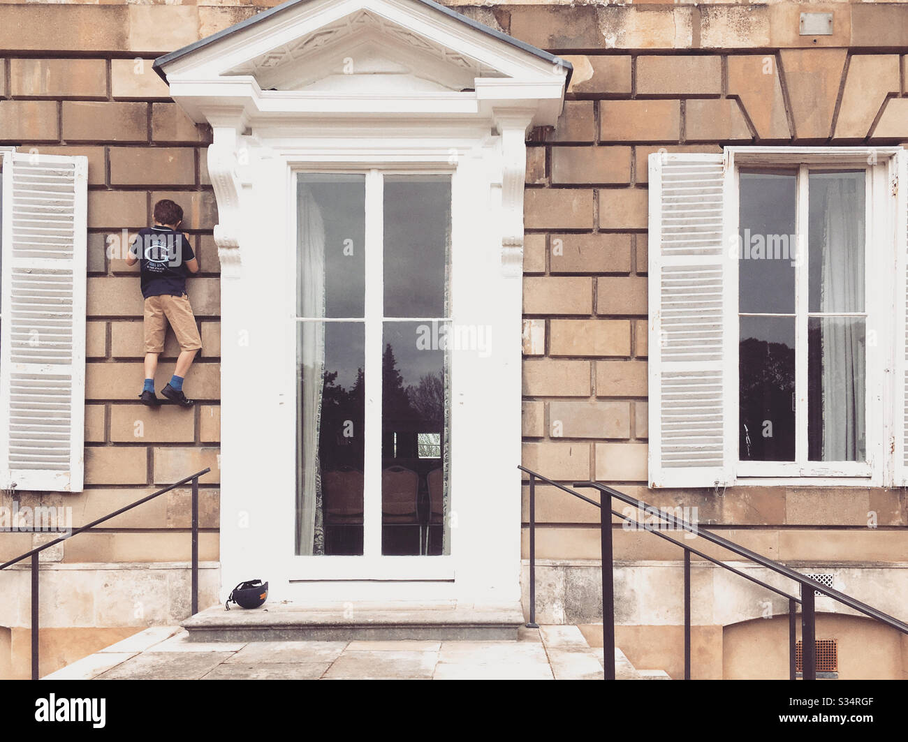 Boy climbing York house Twickenham Uk - Smartphone Captured Stock Image