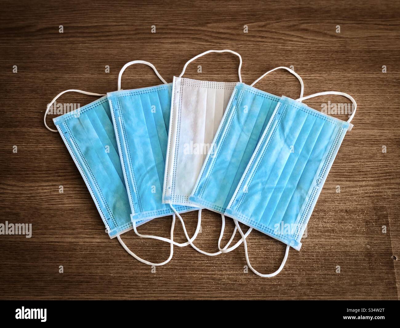 Pile of surgical masks on wooden table - Smartphone Captured Stock Image