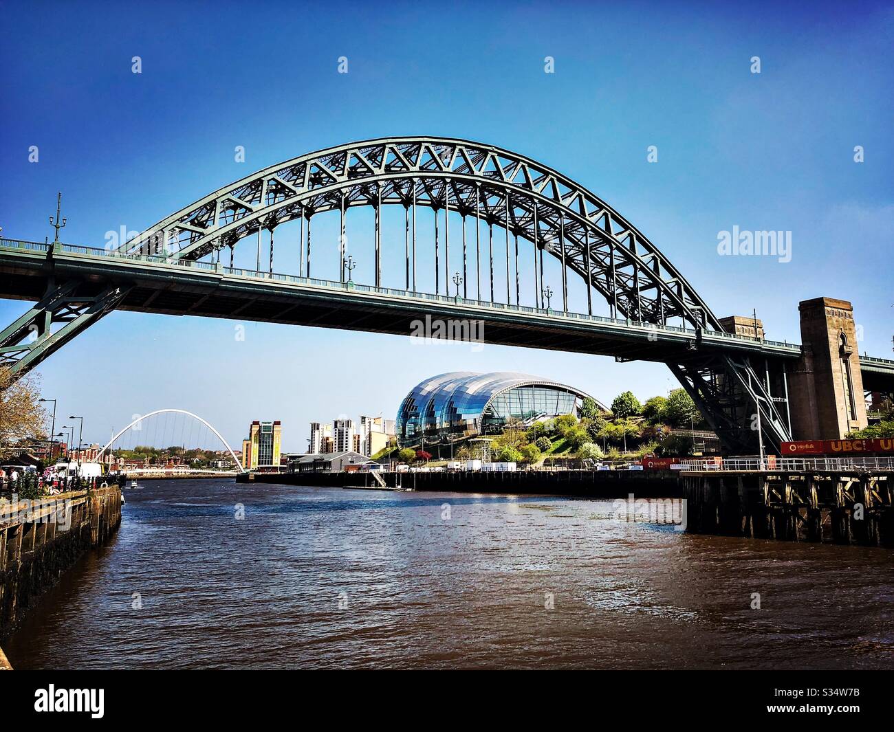 Architecture of Newcastle Quayside under a blue summer sky. Newcastle upon Tyne, North East England. The Tyne Bridge, Sage Gateshead and Millennium Bridge by the River Tyne. - Smartphone Captured Stock Image