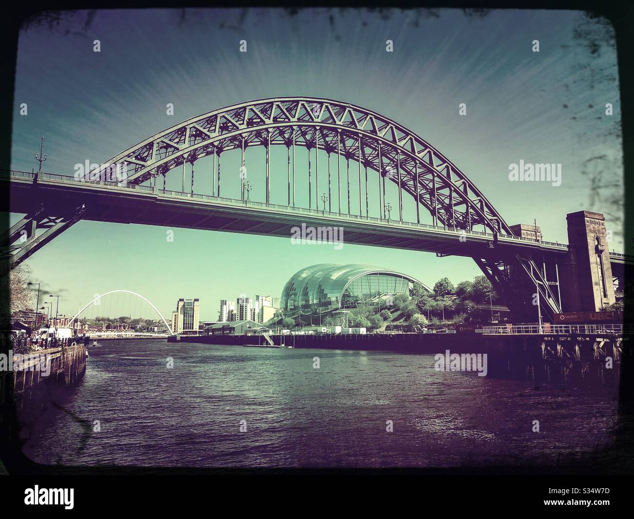 Architecture of Newcastle Quayside under a blue summer sky. Newcastle upon Tyne, North East England. The Tyne Bridge, Sage Gateshead and Millennium Bridge by the River Tyne. - Smartphone Captured Stock Image