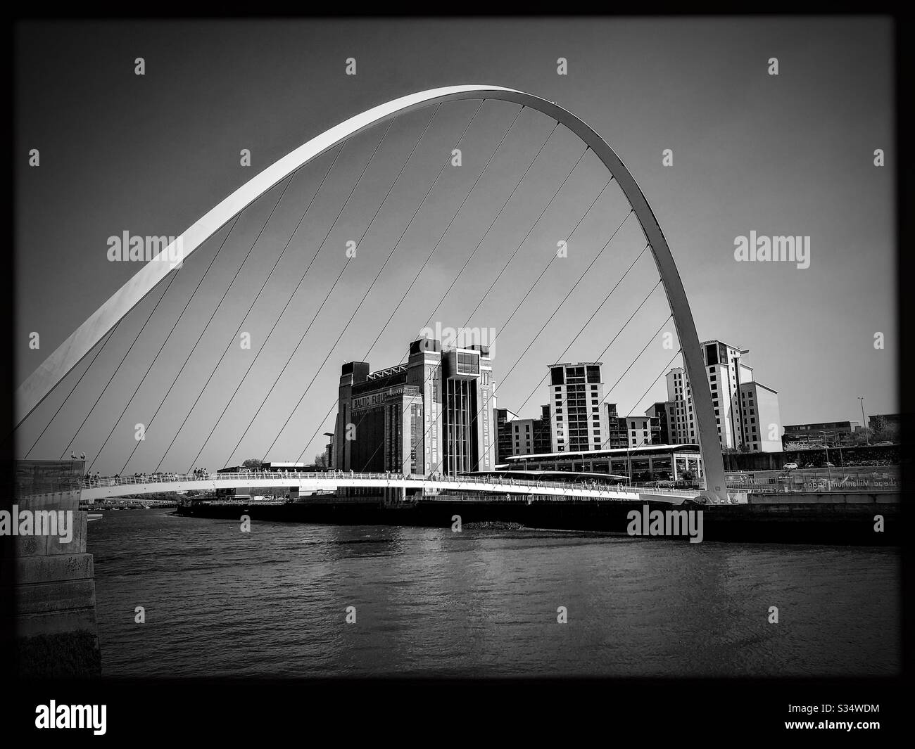 Architecture of Newcastle Quayside. Black and white edit. Newcastle upon Tyne, North East England. The modern arched Millennium Bridge and Baltic Museum - Smartphone Captured Stock Image