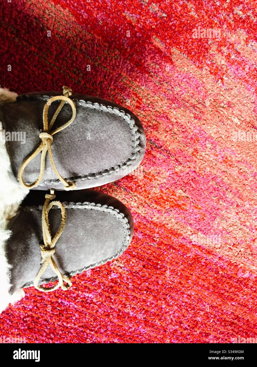 Suede slippers on a brightly colored textured rug - Smartphone Captured Stock Image