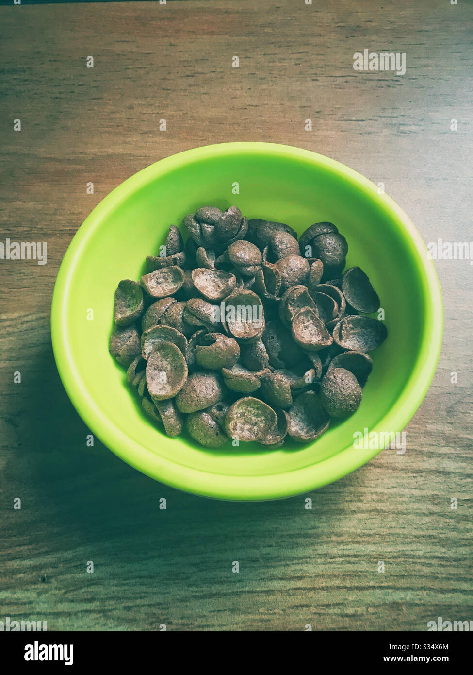 Chocolate cereal in a green plastic bowl. Stock Photo