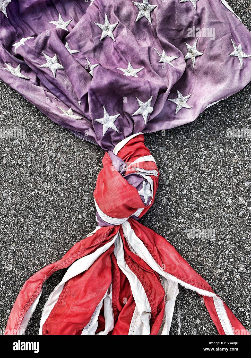 American flag tied in knot in parking lot - Smartphone Captured Stock Image