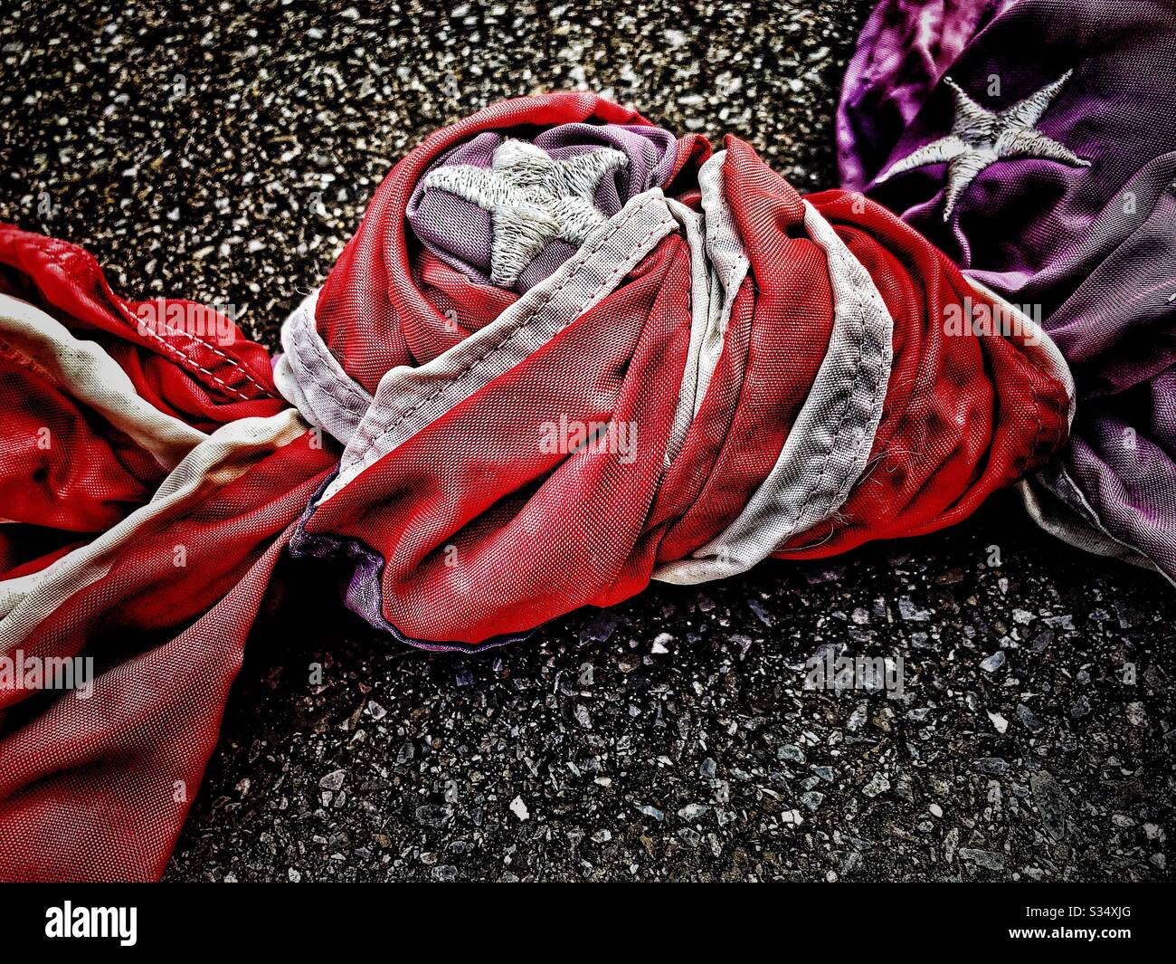 American flag tied in knot in parking lot - Smartphone Captured Stock Image