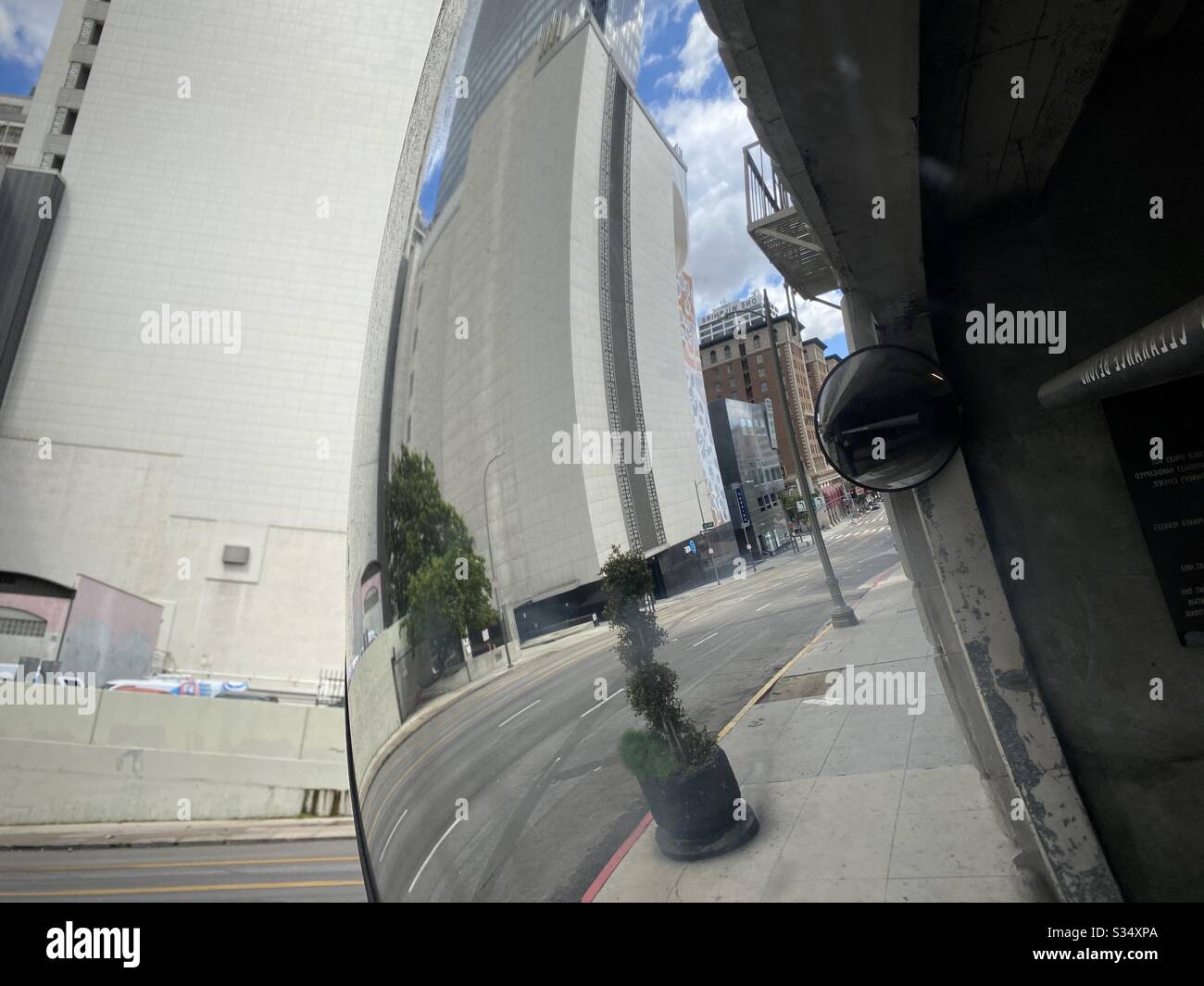 LOS ANGELES, CA, MAR 2020: reflection of buildings around Pershing Square in Downtown, seen in curved mirror by entrance to parking structure - Smartphone Captured Stock Image