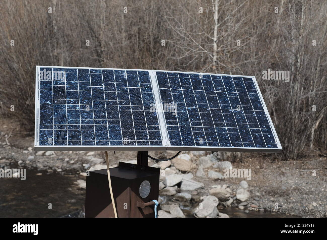 Solar panel in remote location powering stream flow equipment Stock Photo