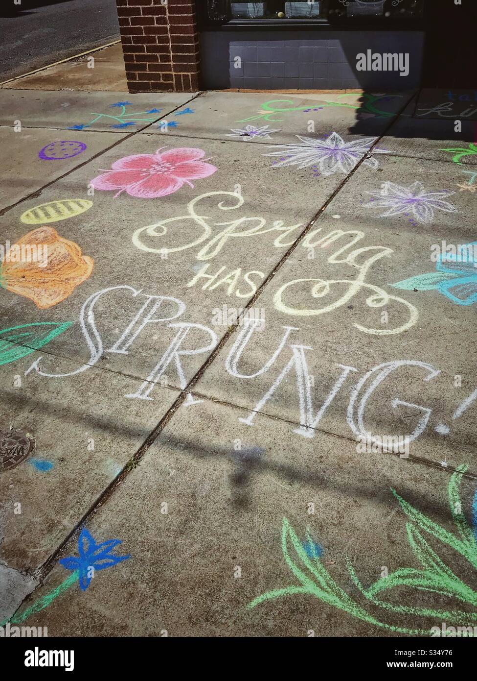 Spring has sprung written in chalk outside store - Smartphone Captured Stock Image