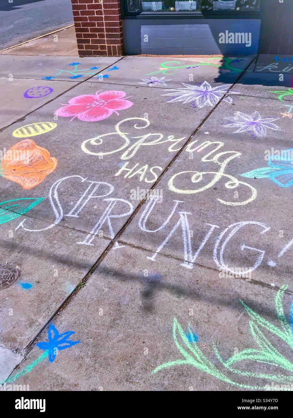 Cheerful spring message in chalk on sidewalk in North Carolina - Smartphone Captured Stock Image