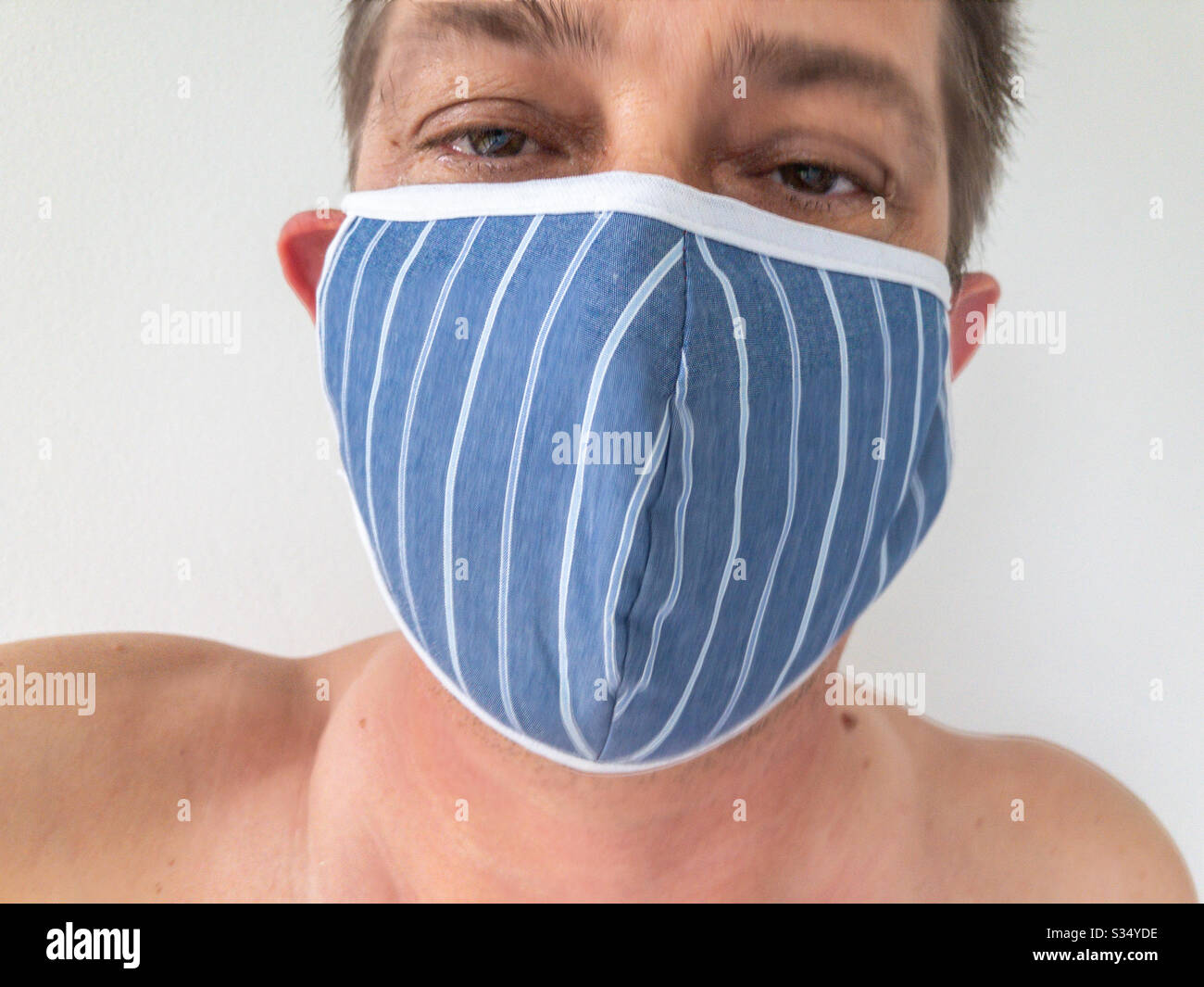 Closeup of man wearing a face mask to protect himself from virus infection - Smartphone Captured Stock Image