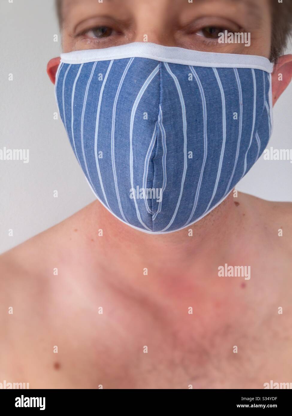 Closeup of man wearing a face mask to protect himself from virus infection - Smartphone Captured Stock Image