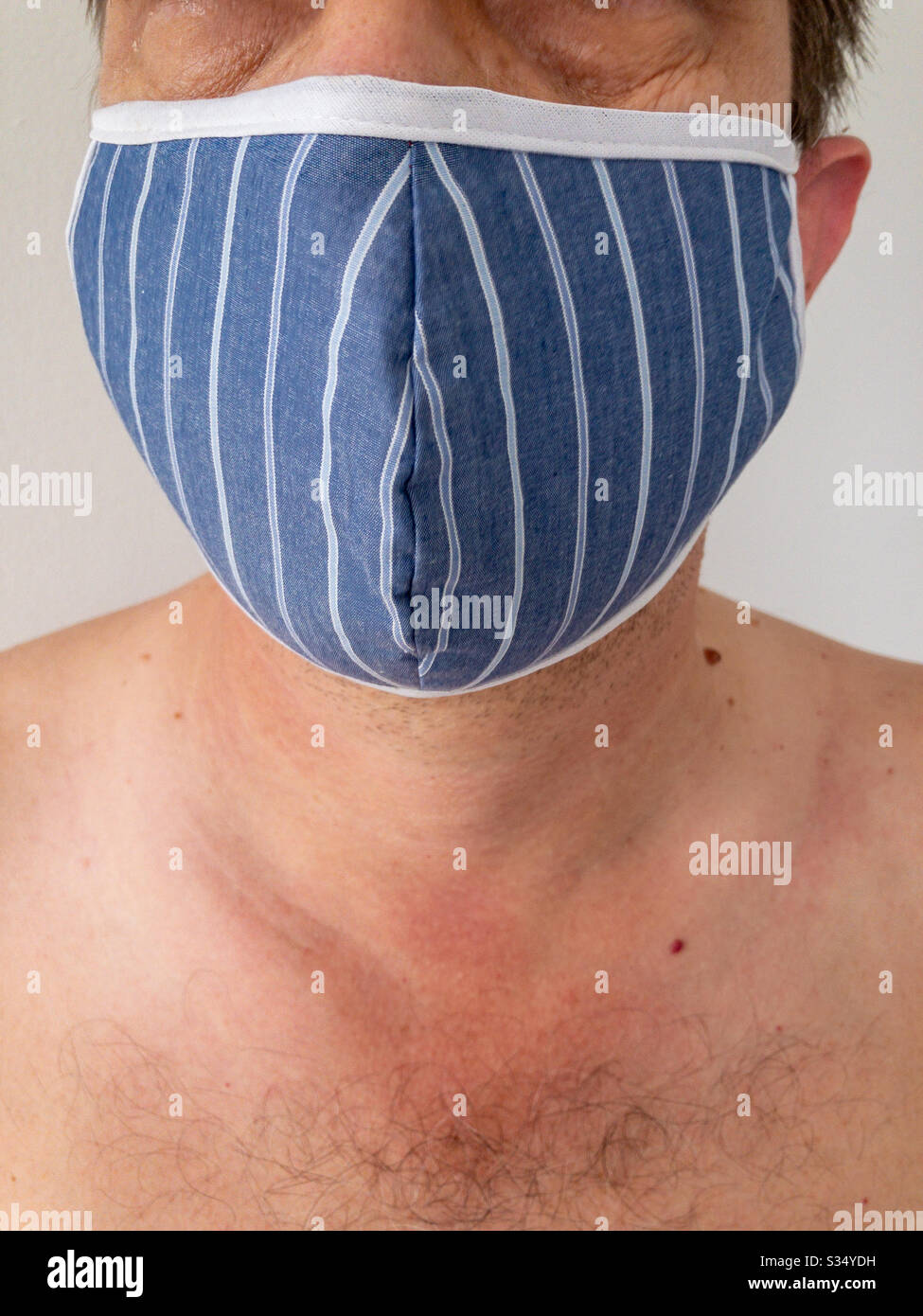 Closeup of man wearing a face mask to protect himself from virus infection - Smartphone Captured Stock Image