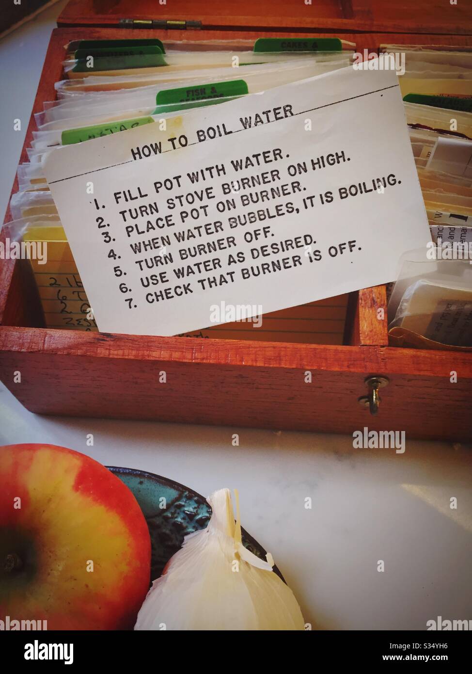 Recipe for boiling water displayed in a handmade wooden recipe box on a residential kitchen counter, USA - Smartphone Captured Stock Image