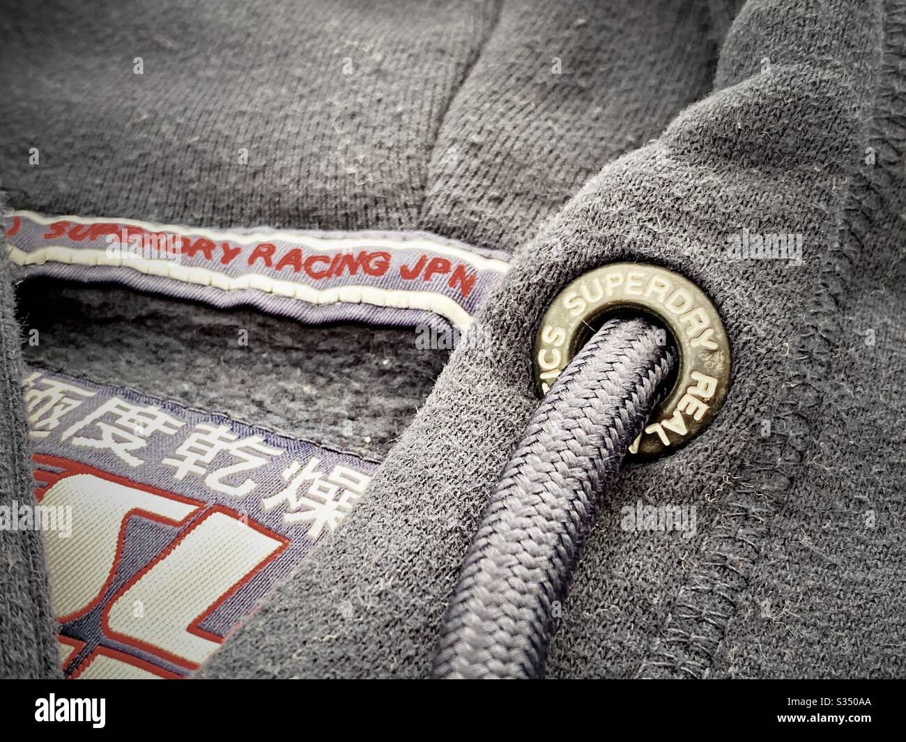 Close up details of designer men’s clothes, menswear. Superdry hooded jumper, hoodie, hoody. Logo and branding - Smartphone Captured Stock Image