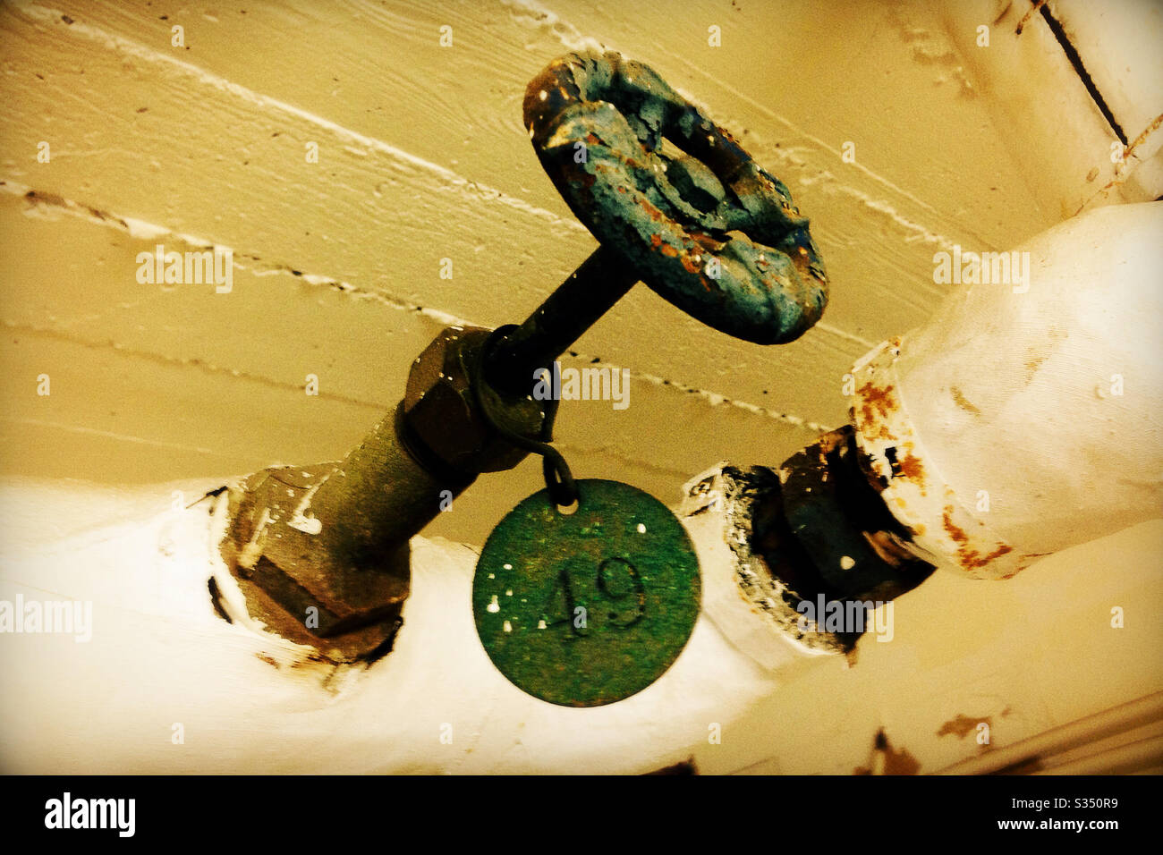 Rusty Valve Handle with Peeling Green Paint and #49 Tag Stock Photo