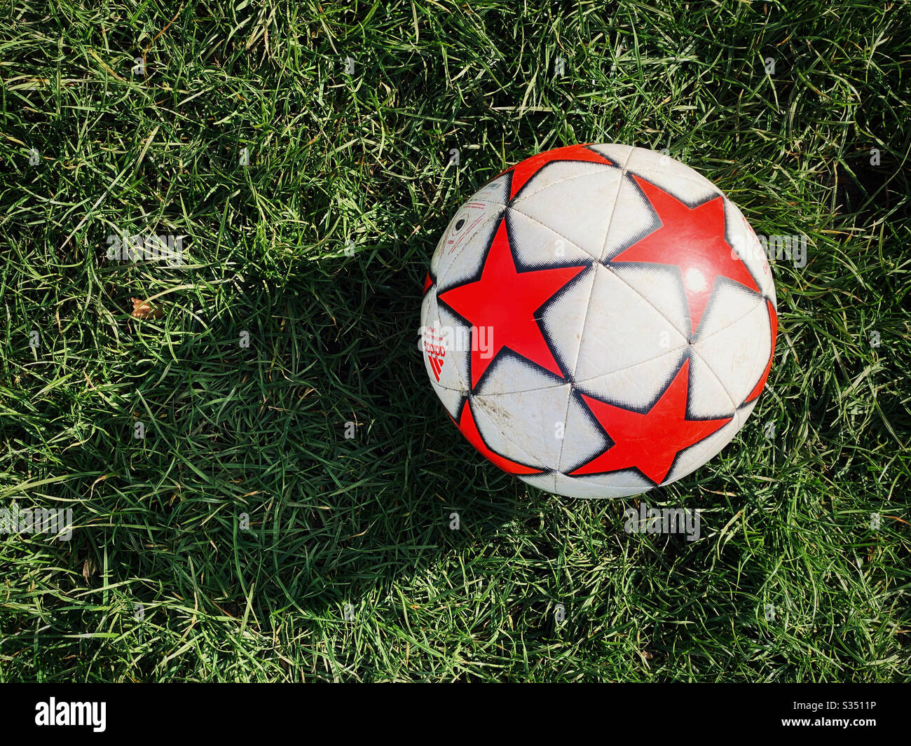 Looking down on a football (or soccer ball). Is a game about to start, or is it just a few kids having a play by kicking a ball around on some grass? Photo Credit - © COLIN HOSKINS. - Smartphone Captured Stock Image