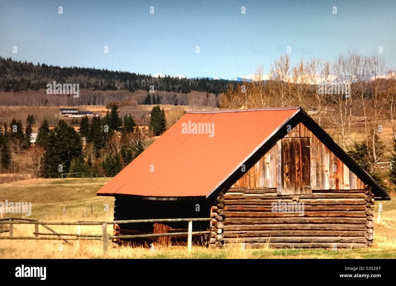 Old farmyard barns, agriculture, country life, wooden, structures,  Alberta, Canada, log barn, woods, foothills, trees,Pole fence - Smartphone Captured Stock Image