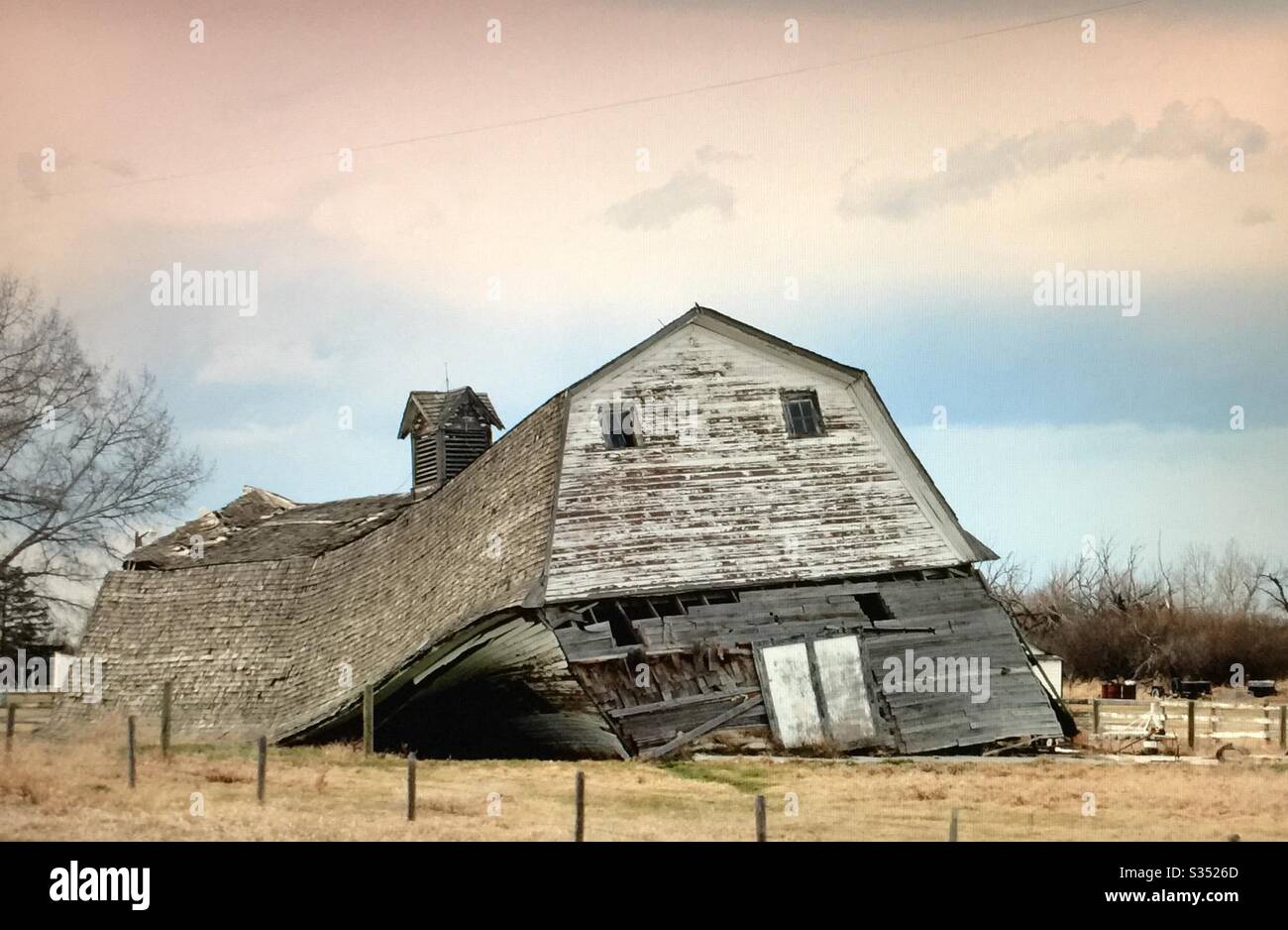 Old farmyard barns, agriculture, country life, wooden, structures,  Alberta, Canada, sagging,collapsing, swayback,pole fence - Smartphone Captured Stock Image