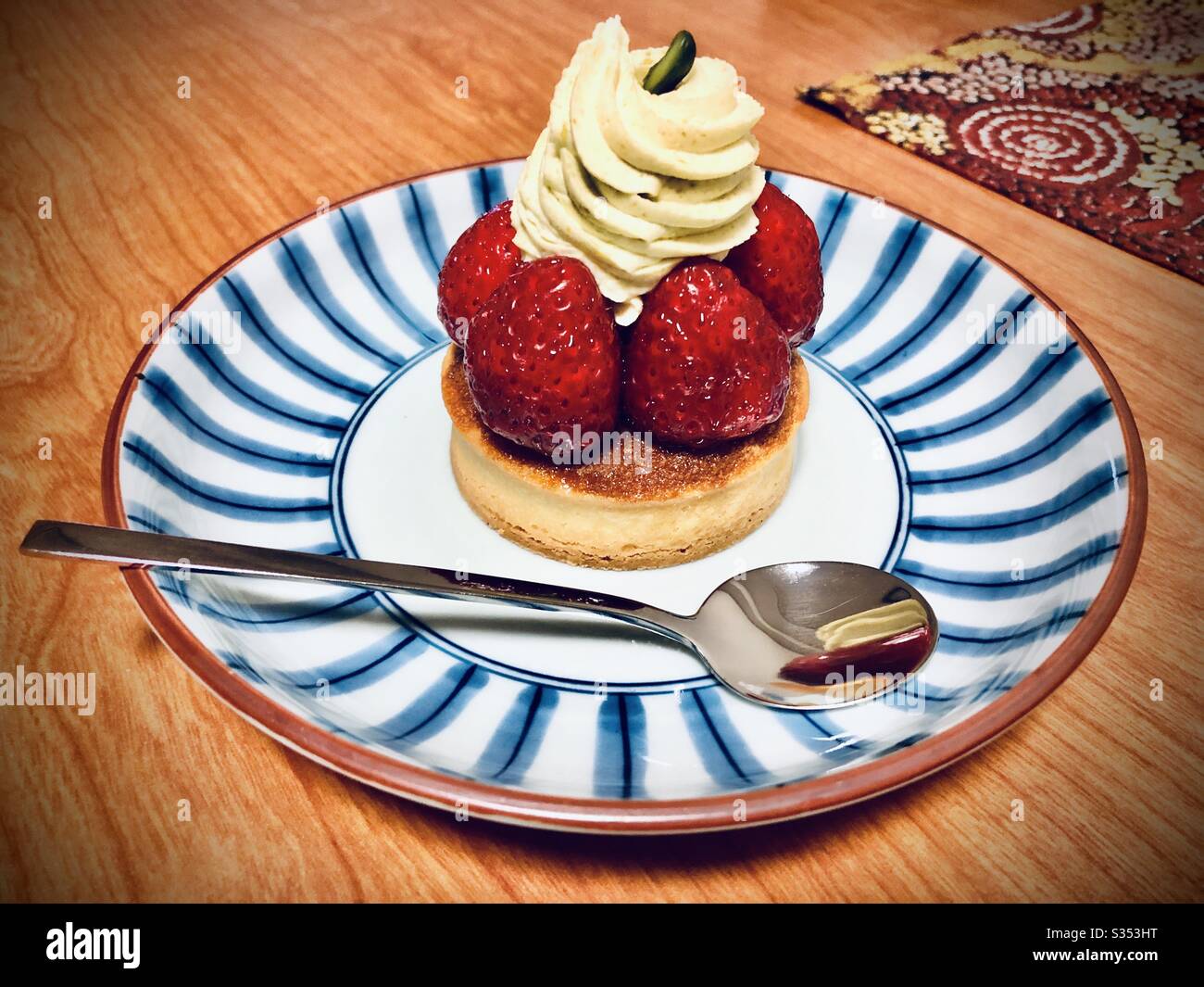 Strawberry and pistachio cream cake on a blue and white ceramic dish - Smartphone Captured Stock Image