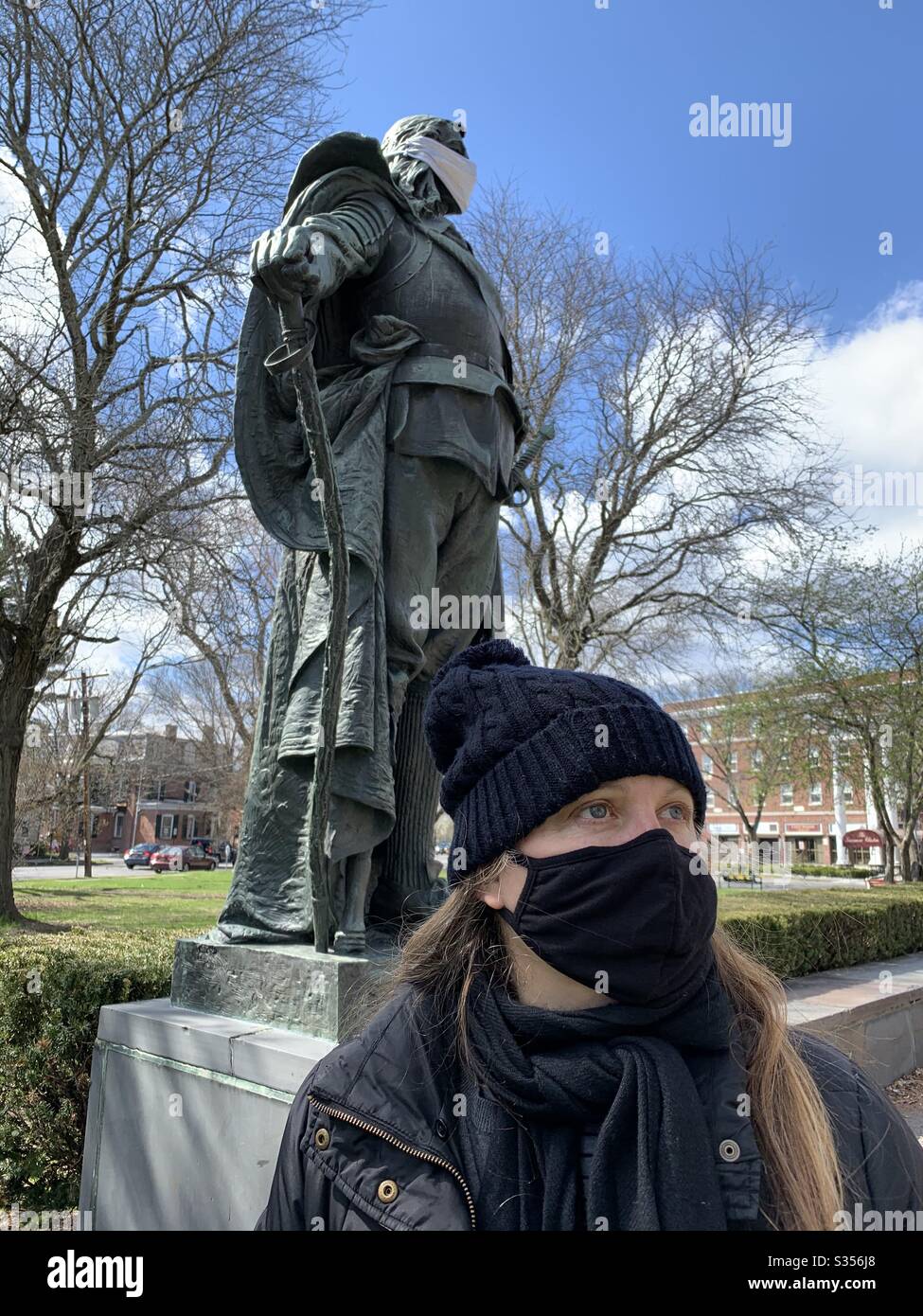 Woman with safety mask in park with statue of  peter Stuyvesant  built first colony in Kingston ny Stock Photo